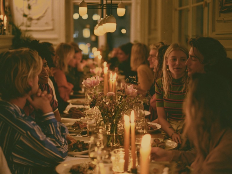 Friends sharing a candlelit dinner at a warmly lit restaurant table